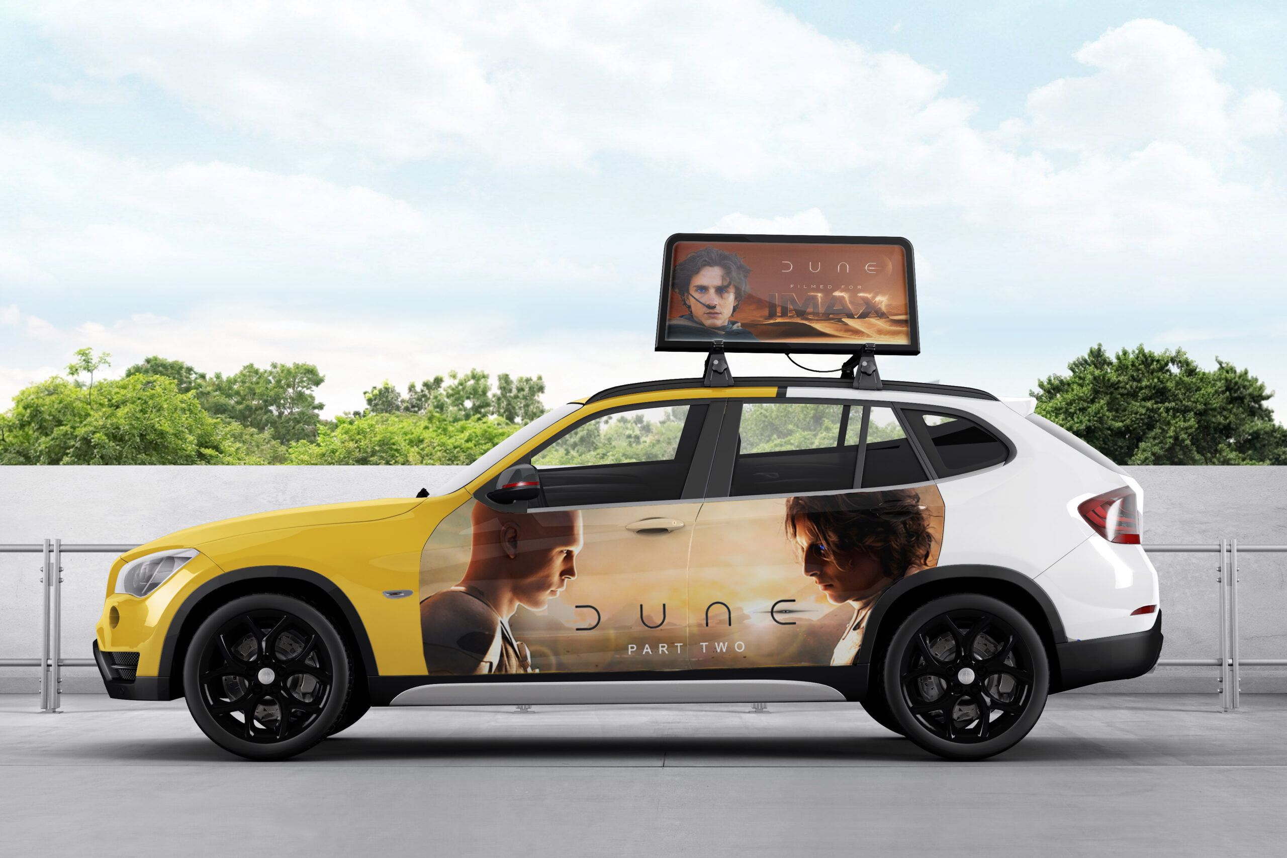 A half-yellow and half-white taxi has promotional banners for the new movie release "Dune: Part 2" on the top and the taxi door.